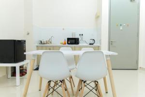 une cuisine avec une table blanche et quatre chaises blanches dans l'établissement FxA Studios Core Soho Suites KLIA 1 & 2 FREE WIFI, à Sepang