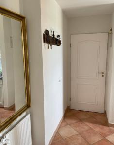 um corredor com um espelho e uma porta branca em Huus Waterkant Wohnung 4 Feeringienwening em Wittdün