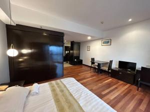 een slaapkamer met een groot bed en een eetkamer bij New-SunwayLagoonFamilySuite-highest floor-2-4pax-Netflix-Balcony-SuperFastInternet in Petaling Jaya