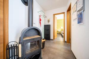 a wood stove in a room with a hallway at Chasa Sotchà Dadora 698 in Scuol