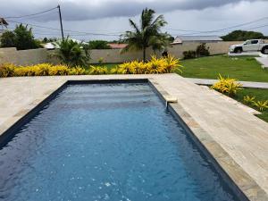 a swimming pool in a yard with a wooden deck at Cap des Anses in Sainte-Anne