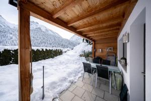 a balcony with a view of a snowy mountain at Chasa Sotchà Dadora 698 in Scuol