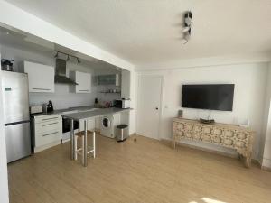 a kitchen with a table and a tv on the wall at Horizonte Azul in Calpe
