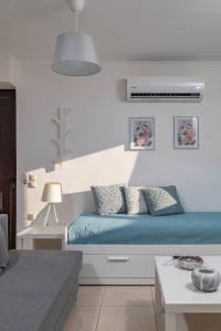 um quarto com uma cama com lençóis e almofadas azuis em Apartment Lia with private eco pool - Amazing view em Chania Town
