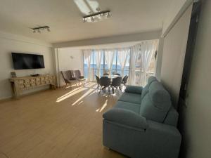 a living room with a couch and a table with chairs at Horizonte Azul in Calpe