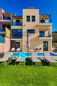 a building with a pool and chairs and an umbrella at Apartment Lia with private eco pool - Amazing view in Chania Town