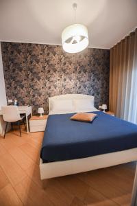 1 dormitorio con 1 cama grande con manta azul en Wojtyla Bari Airport, en Bari Palese