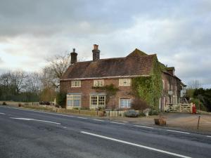 una vecchia casa di mattoni con edera sul lato della strada di 4 Bed in Corfe Mullen THOLD a Corfe Mullen