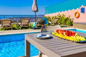 uma bandeja de frutas numa mesa ao lado de uma piscina em Apartment Lia with private eco pool - Amazing view em Chania Town
