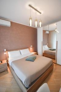 - une chambre avec un grand lit et un miroir dans l'établissement Wojtyla Bari Airport, à Bari Palese