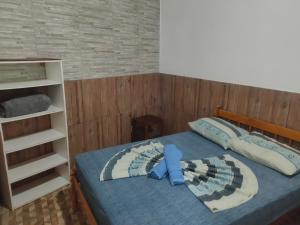 um quarto com uma cama e uma estante de livros em Moradas Vô Ary em Garopaba