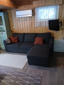 sala de estar con sofá azul y TV en Perälampi, en Huissi