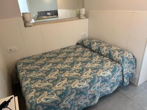a small room with a bed with a blanket at El descanso de Lucía, estudio in Conil de la Frontera