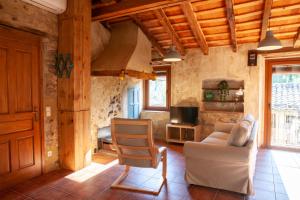 a living room with a couch and a chair at Ca La Remei i Can Benet in Els Hostalets d'en Bas