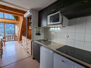 a kitchen with a sink and a stove top oven at Appartement La Clusaz, 3 pièces, 6 personnes - FR-1-459-223 in La Clusaz