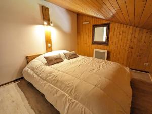 a bedroom with a large bed in a room with wooden walls at Appartement La Clusaz, 3 pièces, 6 personnes - FR-1-459-223 in La Clusaz