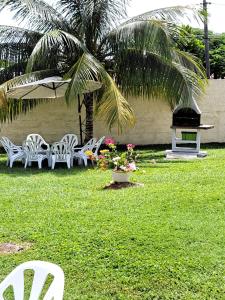 um grupo de cadeiras brancas e uma mesa e uma palmeira em Cap des Anses em Sainte-Anne