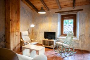 salon z kanapą, krzesłami i telewizorem w obiekcie Ca La Remei i Can Benet w mieście Els Hostalets d'en Bas