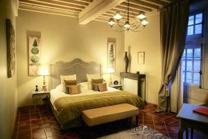 a bedroom with a bed and a chandelier at La Villa Mazarin in Aigues-Mortes