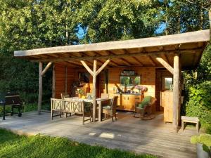 a wooden pavilion with a table and chairs on a deck at Home Bij Zee in Koudekerke
