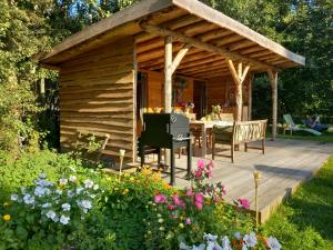 a wooden cabin with a table and chairs on a deck at Home Bij Zee in Koudekerke
