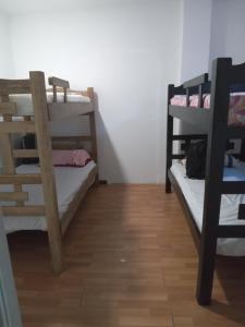 カルタヘナ・デ・インディアスにあるCARTAGENA HOSTALの二段ベッド2組が備わるウッドフロアの客室です。