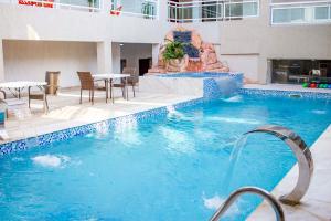 una piscina con una fuente en un edificio en SANA Hotel en Abiyán