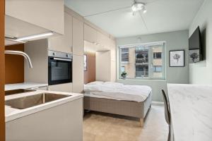 eine Küche mit einem Bett und einem Waschbecken in einem Zimmer in der Unterkunft Leilighet i Stavanger in Stavanger