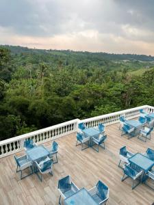 a deck with blue tables and chairs on a balcony at EliJosh Resort and Events Place in Silang