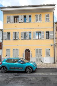 um carro azul estacionado em frente a um edifício amarelo em SE030 - Senigallia, elegante appartamento nel centro storico em Senigallia