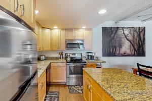 a kitchen with wooden cabinets and stainless steel appliances at Rockies Condo 2407 in Steamboat Springs