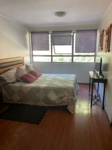 a bedroom with a bed and two windows at Hotel Boutique Azhares in Copiapó