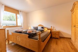a bedroom with a wooden bed and a window at La Stüvetta in Scuol