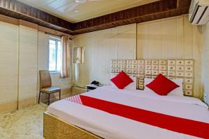 a bedroom with a large bed with red pillows at Hotel Royal Inn in Kolkata
