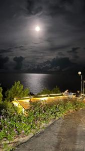 a full moon over the water at night at White's house in Quan Lạn