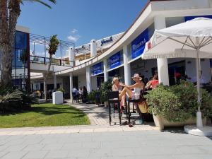 a group of people sitting outside of a building at Chic Home Tropical beach Motril with garage in Motril