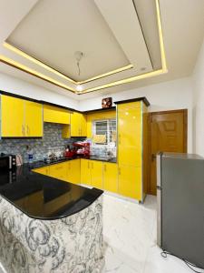 a kitchen with yellow cabinets and a yellow counter top at BED AND BREAKFAST ISLAMABAD - cottages in Islamabad