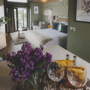 Mellor的住宿－Everything Retreat，一间卧室配有一张床和一张带鲜花和眼镜的桌子