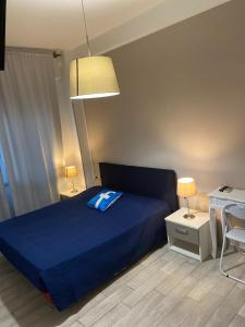 a bedroom with a blue bed and a desk at Guest House Web Room in Pisa