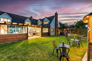una casa con un patio con mesas y sillas en Hen & Stag Retreat Weekend Stay Sleeps 10 to 30 en Thetford