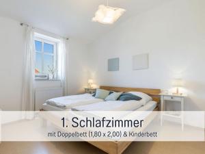 une chambre blanche avec un lit et une fenêtre dans l'établissement Bio Ferienhof Wichtelweide - Fewo Minze, à Fehmarn