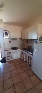 uma cozinha com armários brancos e um frigorífico branco em Etruria Life em Sutri