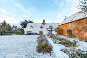 ein Haus mit Schnee auf dem Boden davor in der Unterkunft ryton grange hay barn sleeps 6 in Shrewsbury