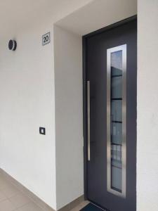 una puerta negra con un espejo en un edificio en NEW ENTRY - Nuova villa nel verde en Mezzana