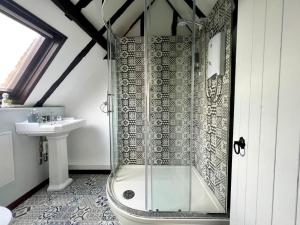 La salle de bains est pourvue d'une douche et d'un lavabo. dans l'établissement Duchess House 2- Spacious & Elegant 3BR 1F, à Colchester
