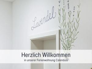 a sign for a bathroom with a mirror and a vase of flowers at Bio Ferienhof Wichtelweide - Fewo Lavendel in Fehmarn