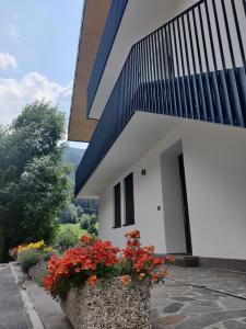 a building with a planter with flowers in front of it at NEW ENTRY - Nuova villa nel verde in Mezzana