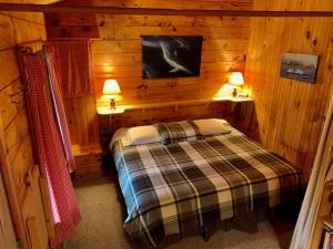 1 dormitorio con 1 cama en una cabaña de madera en Vipilodge en Janvrin Island