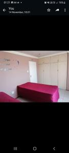 - une chambre avec un lit rose dans l'établissement GLOBAL PRIDE, à Soweto