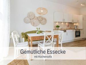 eine Küche und ein Esszimmer mit Tisch und Stühlen in der Unterkunft Bio Ferienhof Wichtelweide - Fewo Thymian in Fehmarn